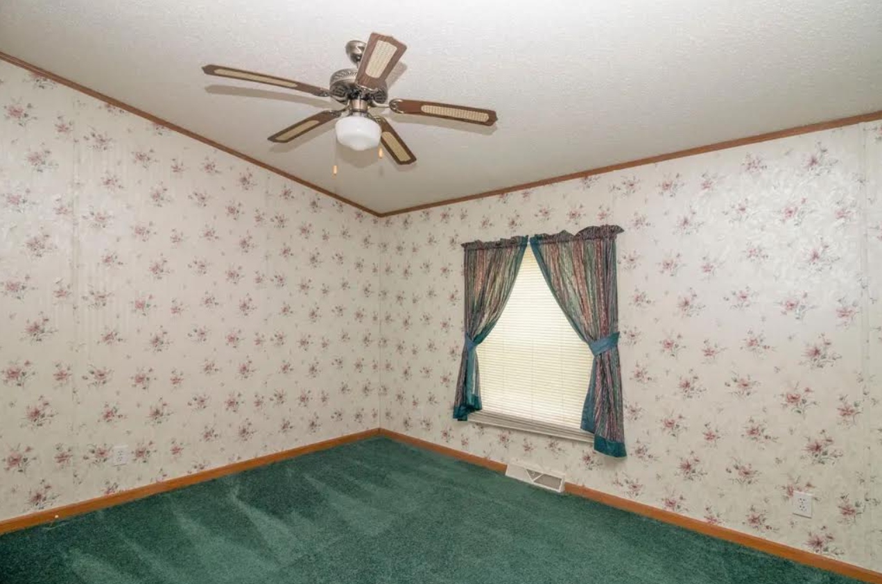 Bedroom before — floral wallpaper, green carpet