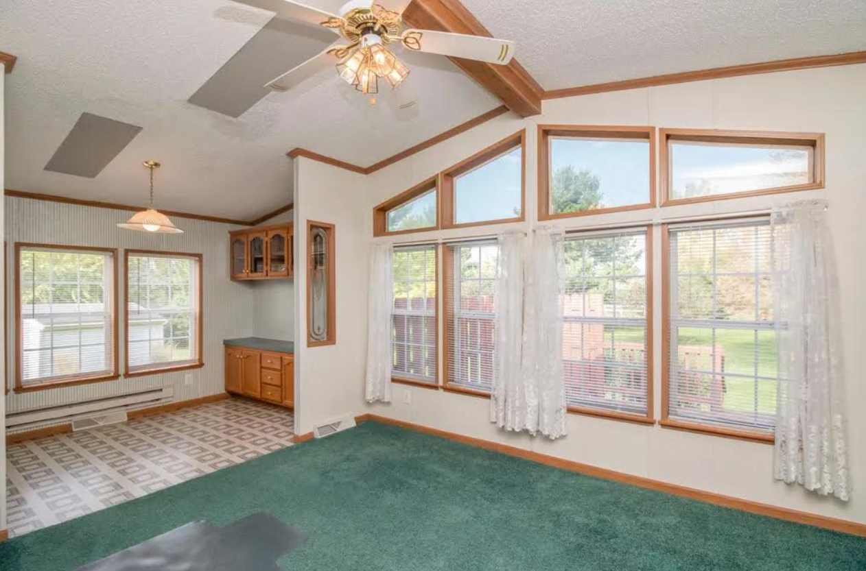 Living room before — green carpet, oak trim