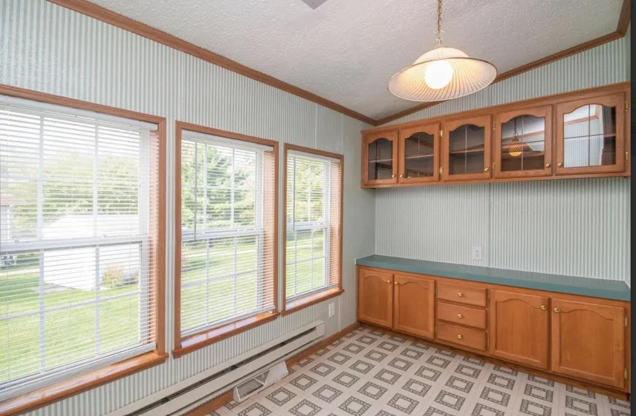 Dining nook before — oak cabinets, wallpaper, linoleum